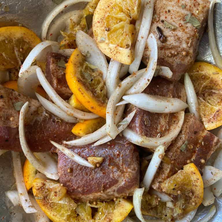 Chunks of Pork Belly mixed with sliced white onion, spices and oranges