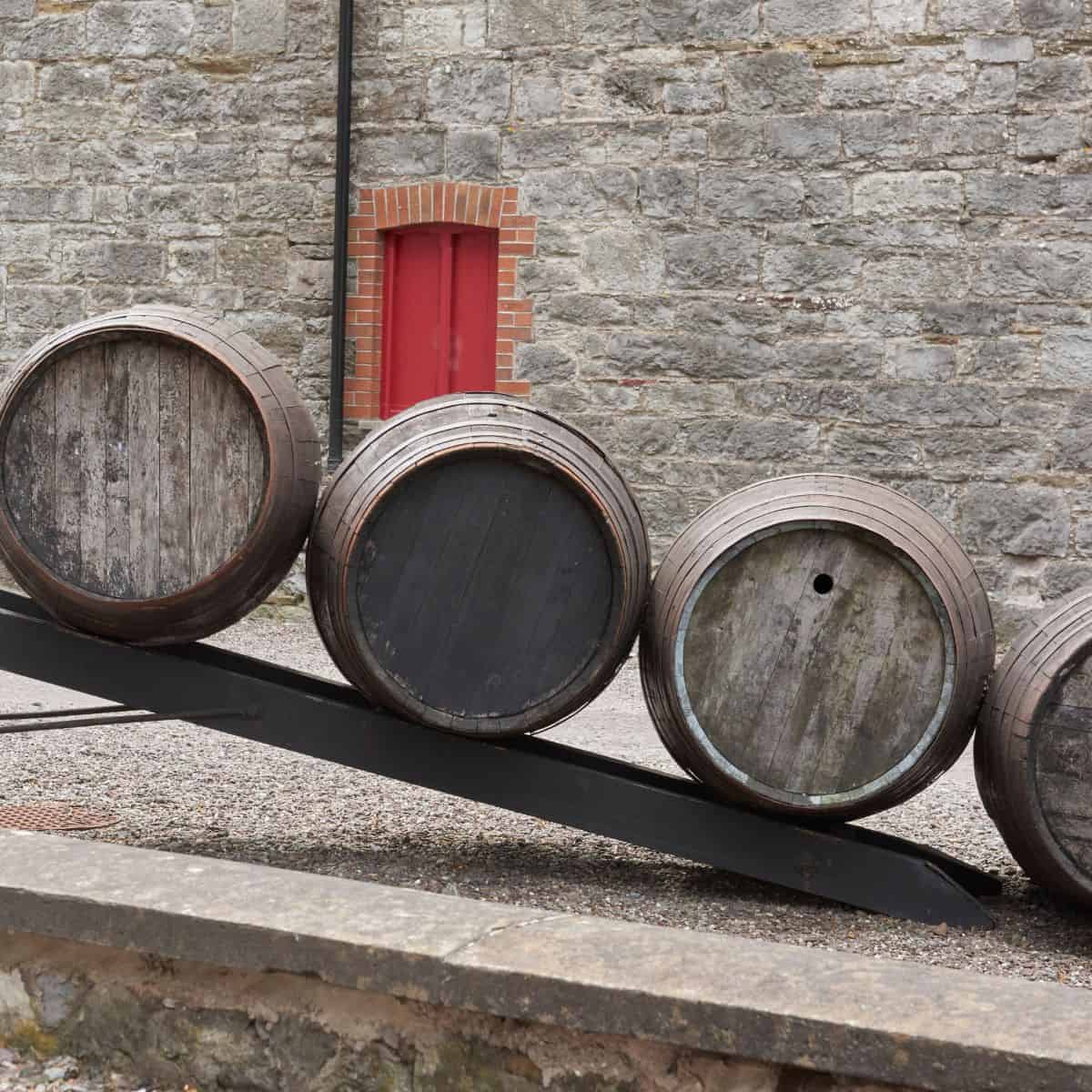 Whiskey Barrels on Ramp in front of stone building with red door